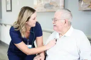 A caregiver and an elderly woman in a wheelchair at Hanford Post Acute