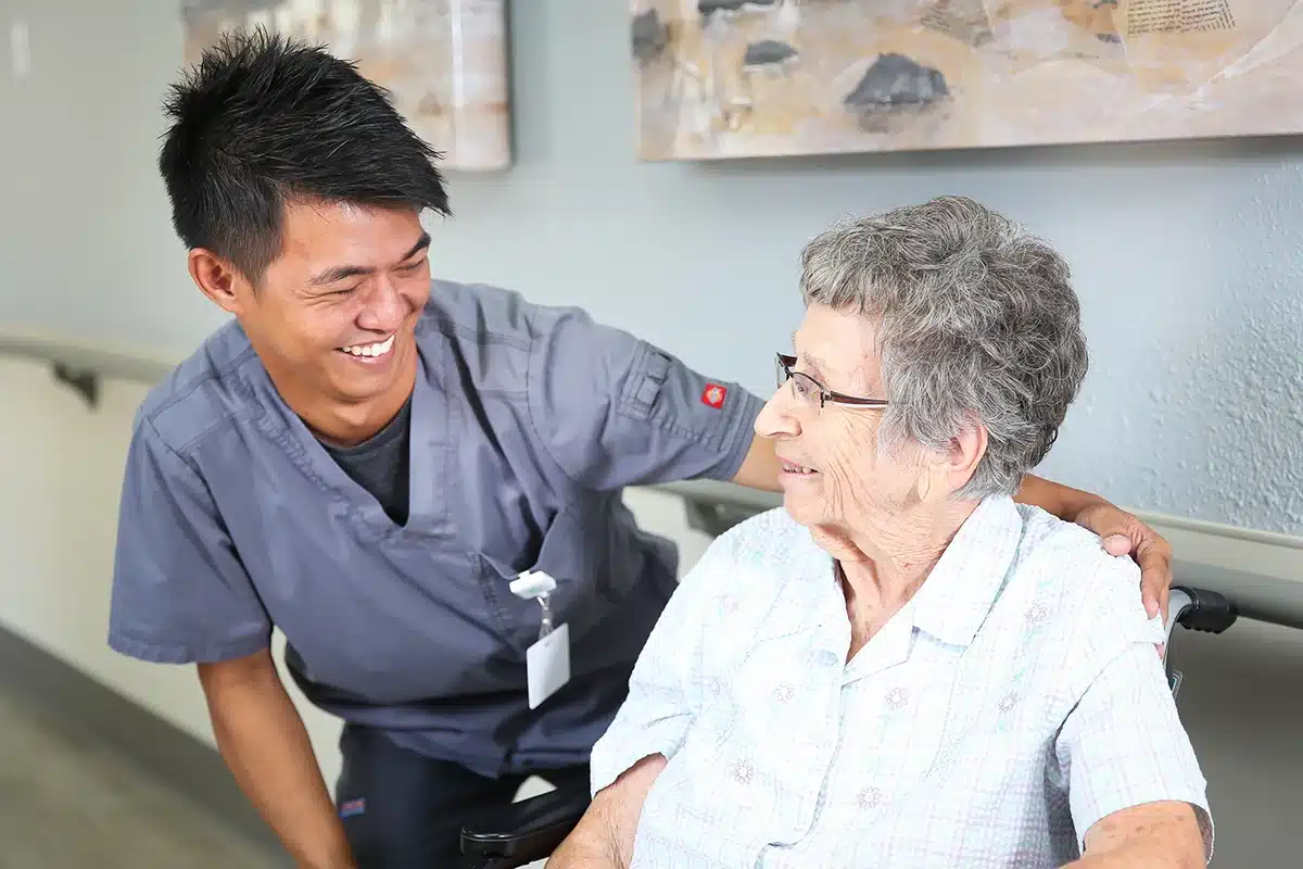 Caregiver and elderly woman in a wheelchair at Hanford Post Acute