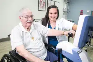 A therapist and an elderly woman in the rehab gym at Hanford Post Acute